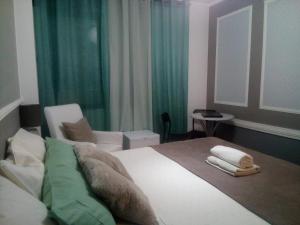 sypialnia z łóżkiem, krzesłem i stołem w obiekcie Guest House Sintra w mieście Queluz