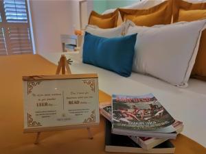 un letto con un cartello e alcuni libri sopra di Hotel Tres Vidas Acapulco a Barra Vieja