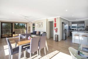 a dining room and living room with a table and chairs at Renovated Coastal getaway with water views in Umina