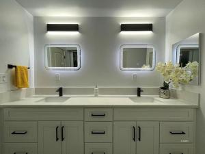 uma casa de banho branca com 2 lavatórios e 2 espelhos em Luxury Lake Home For Larger Private Groups on Acre em Lake Isabella