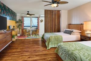 um quarto de hotel com duas camas e uma mesa em MaKai Sunset Inn em Lahaina