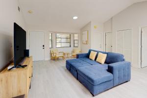 uma sala de estar com um sofá azul e uma televisão em Bahama Breeze em Fort Myers