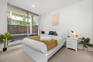 a white bedroom with a bed and a balcony at Rose - The Fringe Escape in Bowden