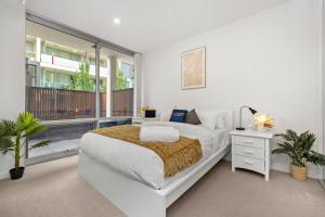 Un dormitorio blanco con una cama y un balcón. en Rose - The Fringe Escape, en Bowden