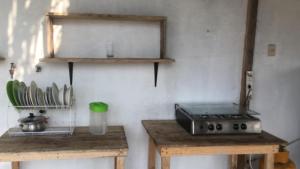 a kitchen with a stove and some wooden tables at Liza, habitación privada de Flor de Lis Beach House in Playas