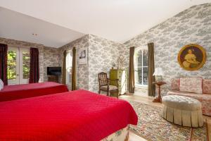 um quarto com 2 camas e um cobertor vermelho em The Old Bank House em Niagara-on-the-Lake