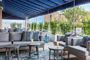 a patio with couches and tables on a rug at Berkeley Oceanfront Hotel in Asbury Park