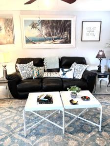 a living room with a black couch and a white coffee table at Cape Canaveral Senior Condominium in Cape Canaveral