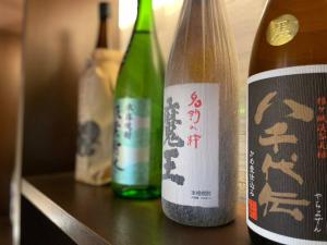 trois bouteilles de vin assises sur une table dans l'établissement 由楽 焼津, à Yaizu