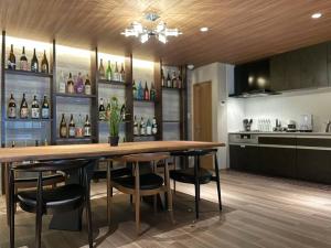 una cocina con una gran mesa de madera y algunas botellas de vino en 由楽 焼津 en Yaizu