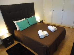 a bedroom with a large bed with two pillows on it at Original Apartments in Albufeira
