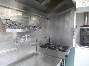 a stainless steel kitchen with a stove and sink at Pennys Accommodation in Palmerston North