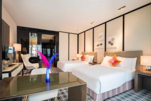 a hotel room with two beds and a desk at W Guangzhou in Guangzhou