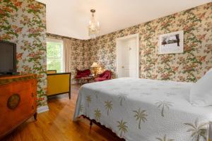 1 dormitorio con 1 cama y TV. en The Old Bank House, en Niagara on the Lake