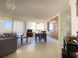 a living room with a couch and a table in it at Departamento Jardín del Mar, Spa y Resort in Coquimbo