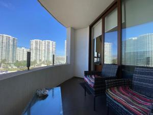 a room with two chairs and a view of the city at Departamento Jardín del Mar, Spa y Resort in Coquimbo