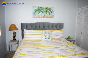 sypialnia z dużym łóżkiem z żółtymi i białymi paskami w obiekcie Marina Pinacate B-101 w mieście Puerto Peñasco