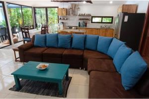 a living room with a brown couch and a table at Golf Beach House w/ Pool (5 min. walk to beach!) in Tambor