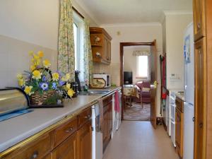 a kitchen with a counter with flowers on it at Rose Rigg Cottage in Kirklinton