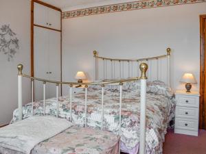 a bedroom with a bed with a metal frame at Rose Rigg Cottage in Kirklinton