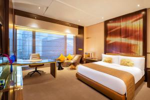 a bedroom with a bed and a desk and a chair at W Guangzhou in Guangzhou
