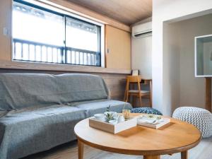 竹田まちホテル في Taketa: غرفة معيشة مع أريكة وطاولة