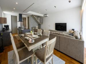 uma sala de jantar e sala de estar com uma mesa e um sofá em Onna Resort em Nago