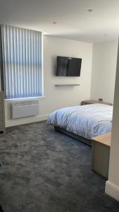 a bedroom with a bed and a flat screen tv at Church inn en-suite rooms with Wi-Fi in Moorside