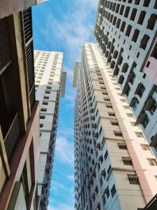 two tall buildings are looking up at the sky at Modern & Spacious 2BR Condo with Netflix & Pool Acess in San Juan Manila in Manila