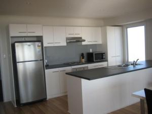 a kitchen with a stainless steel refrigerator and white cabinets at Vista Mare - Point Turton in Point Turton
