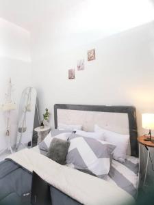 1 dormitorio con 1 cama con almohadas blancas y grises en Townhouse MisNov good escape from Jakarta, 