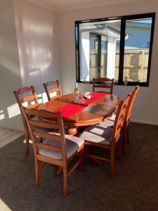 mesa de comedor y sillas con mesa y ventana en Brand new family home, en Richmond