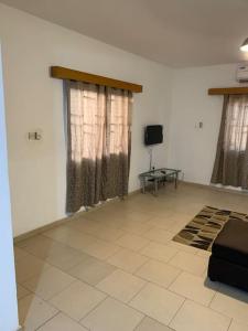 a living room with a couch and a tv at 2 Bedroom @ Devtraco Estates -Tema Comm 25 in Tema
