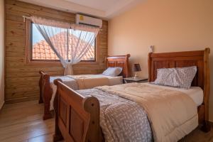 1 dormitorio con 2 camas y ventana en Loft con terraza en Santo Domingo, en La Estrella