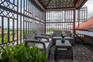 un salón acristalado con sillas, mesas y ventanas en Loft con terraza en Santo Domingo, en La Estrella