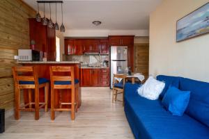 a living room with a blue couch and a kitchen at Loft con terraza en Santo Domingo in La Estrella