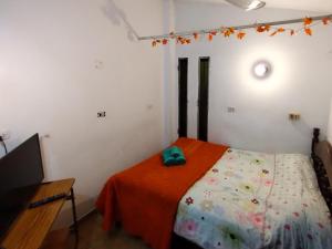 1 dormitorio con 1 cama con manta naranja en T&A RESIDENCE Aeropuerto Ezeiza en Monte Grande