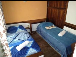 Dos camas en una habitación pequeña con toallas. en T&A RESIDENCE Aeropuerto Ezeiza en Monte Grande