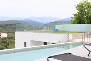 a house with a swimming pool and mountains in the background at Silver Cozy Getaway - 3 Pearls Pool Retreat in Dhémbla