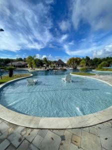 a swimming pool with two chairs in the water at Iloa Residence Ap 103 K Barra de São Miguel AL in Barra de São Miguel