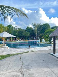 a swimming pool with a person in the water at Iloa Residence Ap 103 K Barra de São Miguel AL in Barra de São Miguel +6 photos