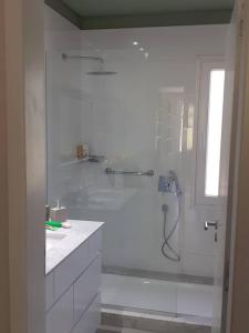 a white bathroom with a shower and a tub at Casa de Campo con Bosque y Pileta in Tandil