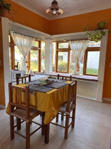 comedor con mesa, sillas y ventanas en La Pichonita en Lozano