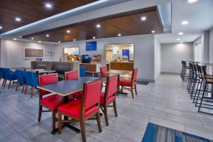 a restaurant with tables and chairs and a counter at Holiday Inn Express Hotel and Suites Katy, an IHG Hotel in Katy