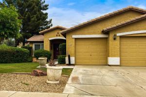 a house with two garage doors in a yard at Good Memories in Goodyear in Goodyear