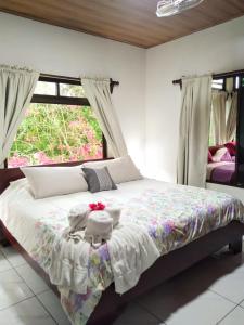 Schlafzimmer mit einem großen Bett und einem Fenster in der Unterkunft Tranquil Eventlocation at Lake Arenal in Tronadora