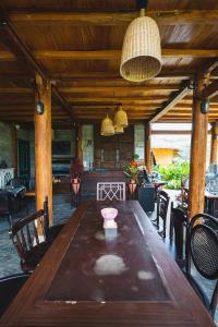 Làng CacにあるTớ Dày Du Già Villageの椅子付きの部屋内の大きな木製テーブル