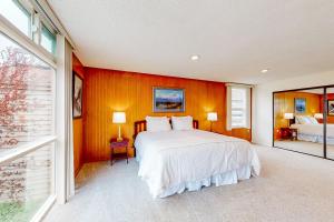 a bedroom with a large white bed and orange walls at The Garden Suite on M Street in Anchorage