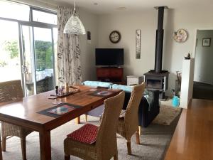 a living room with a wooden table and a fireplace at Al Der Rocs B & B in Kerikeri