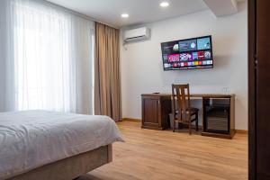 ein Schlafzimmer mit einem Bett und einem Schreibtisch mit Stuhl in der Unterkunft Voyager in Mamaia Nord – Năvodari